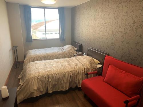 um quarto com uma cama e uma cadeira vermelha em Sado - Hotel - Vacation STAY 82496 em Sado