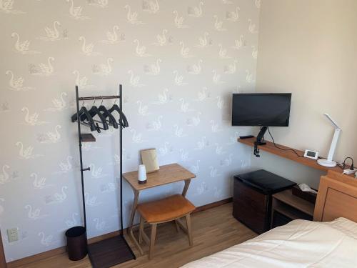 Schlafzimmer mit einem Bett, einem Schreibtisch und einem TV in der Unterkunft Sado - Hotel - Vacation STAY 82477 in Sado