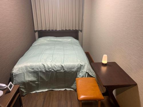 Kleines Zimmer mit einem Bett, einem Schreibtisch und einem Tisch in der Unterkunft Sado - Hotel - Vacation STAY 82494 in Sado