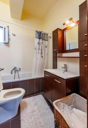 a bathroom with a toilet and a sink and a tub at Jasmine in Preveza
