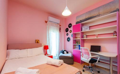 a bedroom with pink walls and a desk and a bed at Jasmine in Preveza