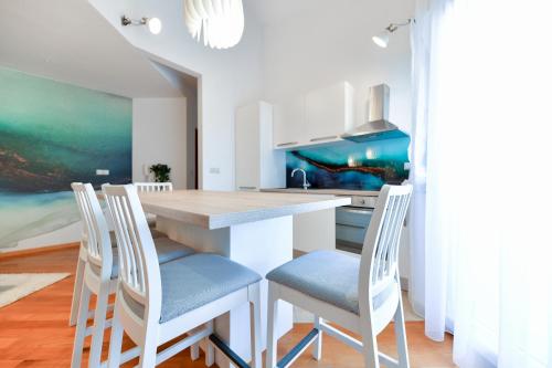 a kitchen with a wooden table and chairs at Bellevue Hill apartment in Zadar