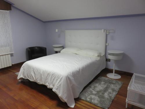 a bedroom with a large white bed and a sink at Estancia Edurne in Mungia