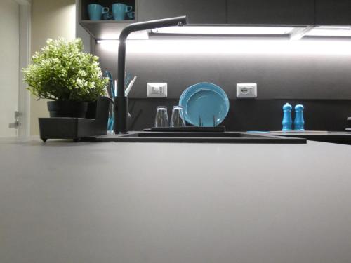 a kitchen sink with a blue plate on the counter at Town-Beach Home in Civitanova Marche