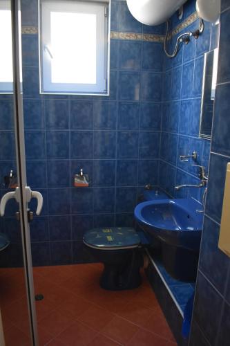 uma casa de banho azul com um WC e um lavatório em Студио Одеса 22 em Sozopol