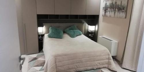 a bedroom with a large white bed with green pillows at Town-Beach Home in Civitanova Marche