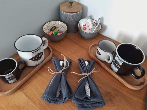 a wooden table with three coffee mugs and bows at La Cour in Charleville-Mézières