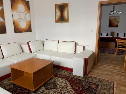 a living room with a white couch and a table at Antik Hotel Sofia in Litomyšl