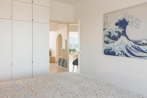a bedroom with a painting of the great wave at SeaDreams in Middelkerke