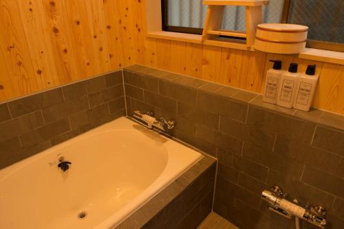a bathroom with a bath tub in a room at SyukuyaYokohama Main Building 1F - Vacation STAY 82573 in Kitagatamachi