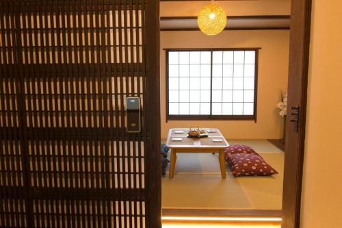Zugang zu einem Zimmer mit einem Tisch und einem Fenster in der Unterkunft SyukuyaYokohama Main Building 2F - Vacation STAY 82577 in Kitagatamachi