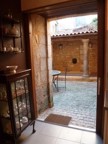 une porte ouverte sur une cour avec une terrasse. dans l'établissement Appartement Le Cardinal, à Sarlat-la-Canéda