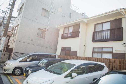 3 voitures garées dans un parking devant un bâtiment dans l'établissement SyukuyaYokohama Main Building 2F - Vacation STAY 82577, à Kitagatamachi
