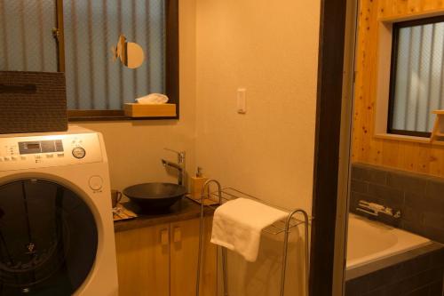 a bathroom with a washing machine and a sink at SyukuyaYokohama Main Building 2F - Vacation STAY 82577 in Kitagatamachi