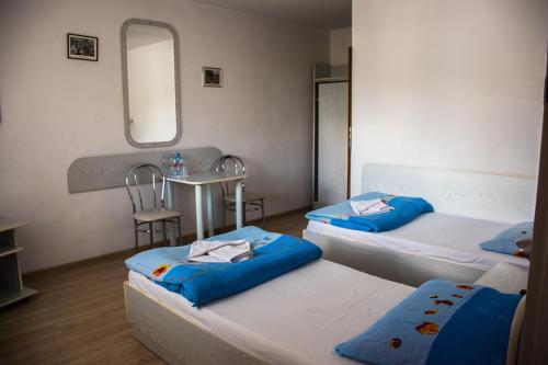a room with two beds and a sink and a mirror at Villa Malva in Łomianki
