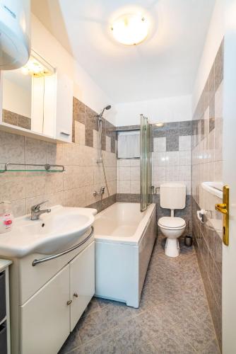 a bathroom with a sink and a toilet and a tub at Olive House Zadar in Zadar