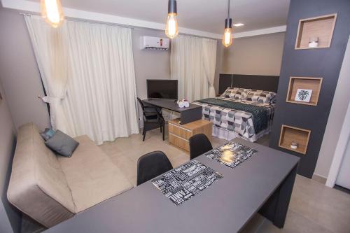 een woonkamer met een bed en een eetkamer bij Studio Andar Alto e Face Norte - ALL1611 in Curitiba