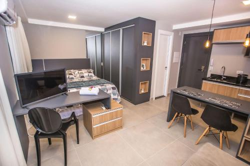 een slaapkamer met een bed, een bureau en stoelen bij Studio Andar Alto e Face Norte - ALL1611 in Curitiba