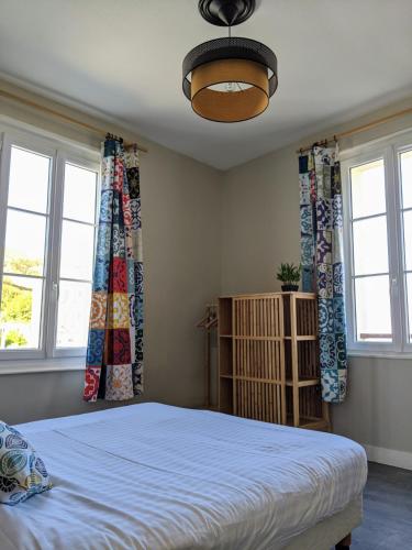 1 dormitorio con 1 cama y 2 ventanas en L'Aiguille Creuse, en Étretat