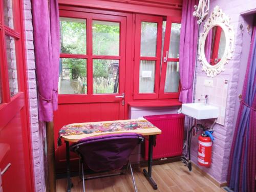 a red bathroom with a table and a sink at Forgatz' Studio in Bruges