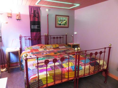 a bedroom with a bed with a colorful quilt at Forgatz' Studio in Bruges