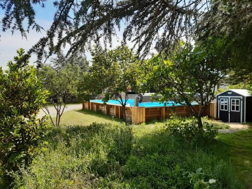 een huis met een zwembad in een tuin bij La maison bleue in Corpeau
