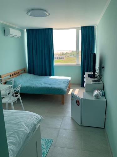 a hotel room with two beds and a table and a window at Променад "MAXXSEA" in Zatoka