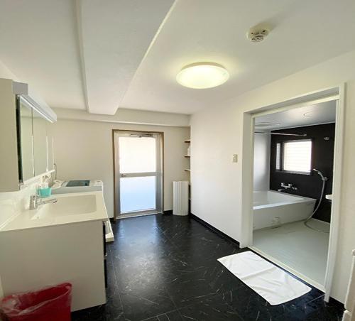 een badkamer met een bad, een wastafel en een spiegel bij La Foret Fujimi - Vacation STAY 83089 in Hiroshima