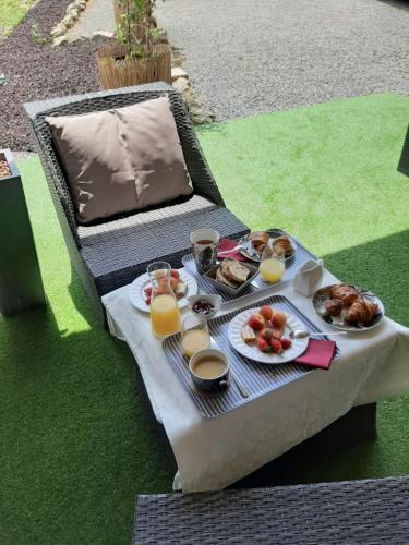 - une table de pique-nique avec des aliments pour le petit-déjeuner et du jus d'orange dans l'établissement La Villa Claudia, à Pennautier