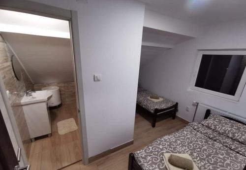 Habitación pequeña con cama y baño. en Apartmani Maja 2, en Zrenjanin