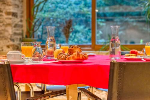 a table with a plate of food on a red table cloth at La Bastide d'Albignac in Le Dourn