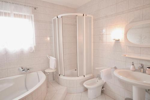 ein Badezimmer mit einer Badewanne, einem WC und einem Waschbecken in der Unterkunft Ferienwohnung Leutschach in Leutschach