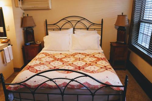 a bed with a quilt and pillows in a bedroom at Iowa House Historic Inn in Ames
