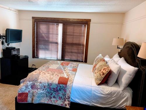 a bedroom with a bed with a quilt on it at Iowa House Historic Inn in Ames