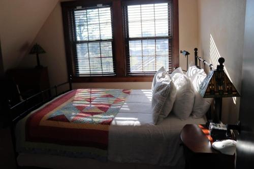 a bedroom with a bed with a quilt on it at Iowa House Historic Inn in Ames
