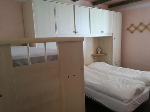 a bedroom with a bunk bed and white cabinets at Baita la Gioiosa in Livemmo