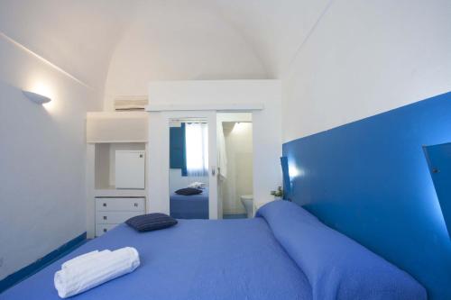 a bedroom with a blue bed with a blue headboard at Blusanvito in San Vito lo Capo
