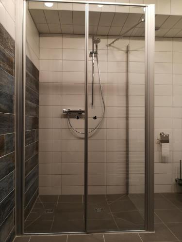 a shower with a glass door in a bathroom at Liebevoll hinterm Deich in Lehe
