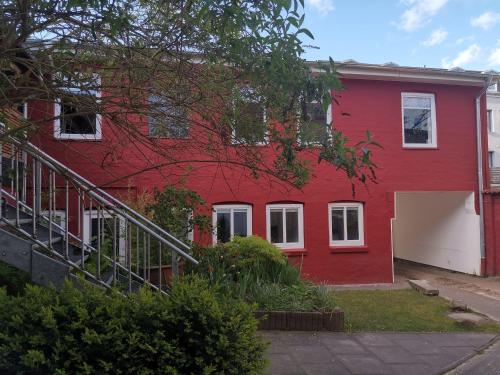 a red house with a staircase in front of it at Westliche Höhe in Flensburg