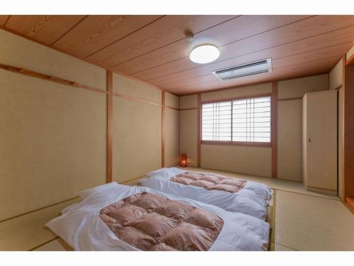 SERENDIP HOTEL GOTO - Vacation STAY 82393 في غوتو: غرفة نوم مع سرير في غرفة مع نافذة