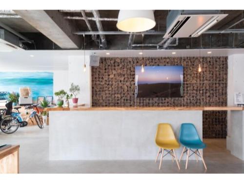 a bar with two chairs and a tv on a wall at SERENDIP HOTEL GOTO - Vacation STAY 82393 in Goto