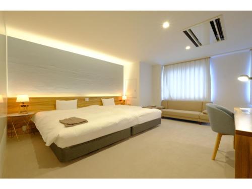 a bedroom with a large white bed and a couch at SERENDIP HOTEL GOTO - Vacation STAY 82543 in Goto