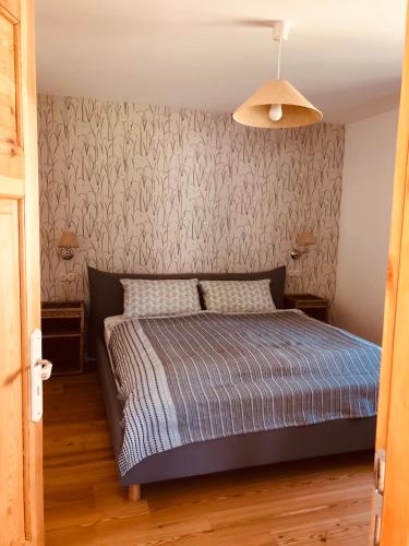 a bedroom with a bed and a wall at Katjas Kate Gartenwohnung in Prerow