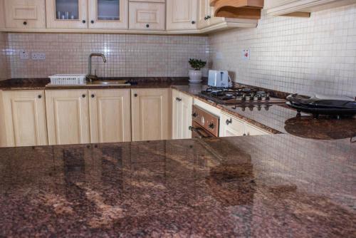 a kitchen with white cabinets and a counter top at Ta Marija in Żebbuġ