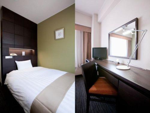 a hotel room with a bed and a desk with a mirror at Hotel St Palace Kurayoshi - Vacation STAY 82272 in Kurayoshi