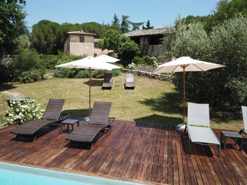 a deck with chairs and umbrellas next to a pool at Borgo dei Fondi in Siena