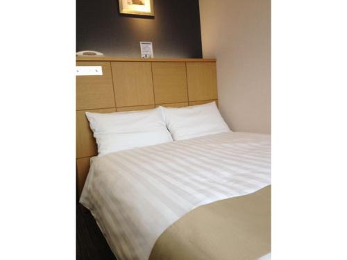 a bedroom with a bed with white sheets at Hotel St Palace Kurayoshi - Vacation STAY 82277 in Kurayoshi