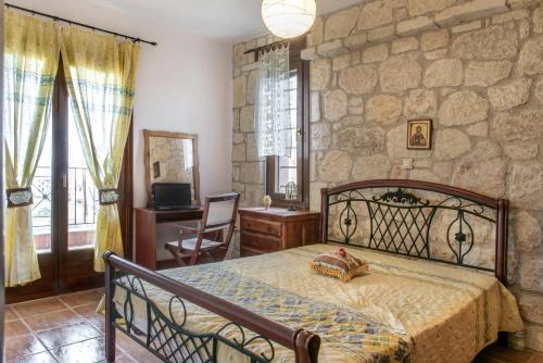 1 dormitorio con cama y pared de piedra en Danai House, en Nea Roda
