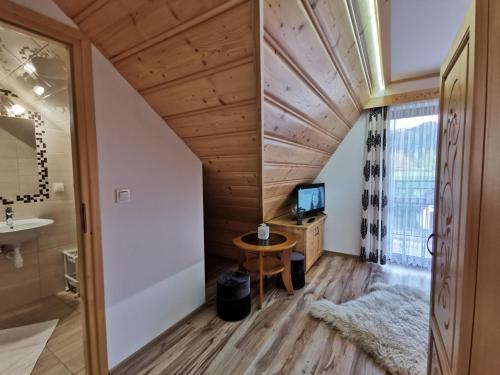 a room with a bathroom with a sink and a mirror at Pokoje Gościnne Kurosik in Zakopane