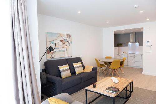 ein Wohnzimmer mit Sofa und Tisch in der Unterkunft CONCHEIROS 5 APARTAMENTOS TURISTICOS in Santiago de Compostela